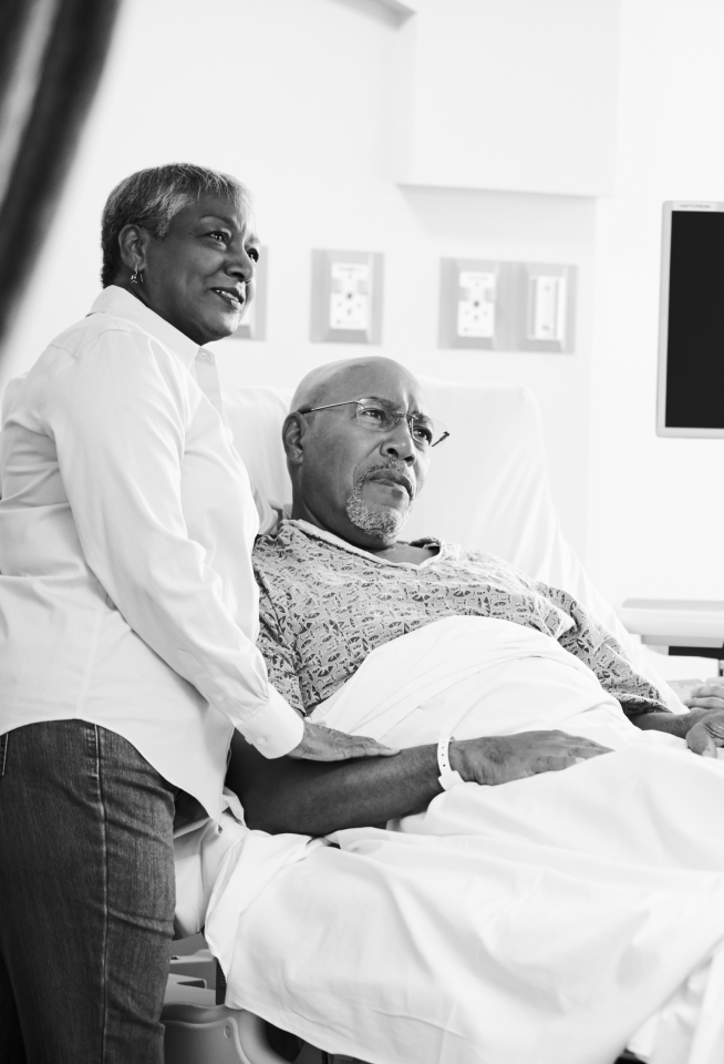 Myeloma patient in hospital bed, talking with spouse, doctor, and nurse.
